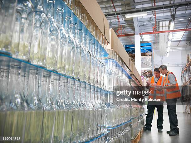 factory workers examining bottles - bottling stock pictures, royalty-free photos & images