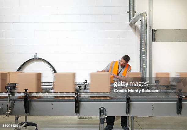 factory worker checking boxes in plant - fließband stock-fotos und bilder