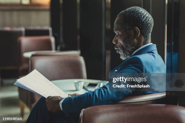 elagant businessman reading daily newspaper at cafe - splash news stock-fotos und bilder