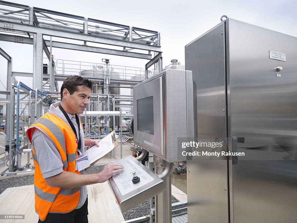 Worker with machinery in bottling plant