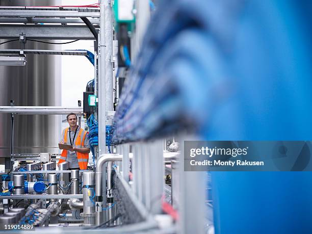 worker with machinery in bottling plant - manufacturing machinery stock pictures, royalty-free photos & images