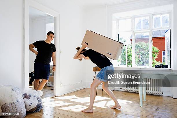 man watching girlfriend carry heavy box - woman carrying stock pictures, royalty-free photos & images