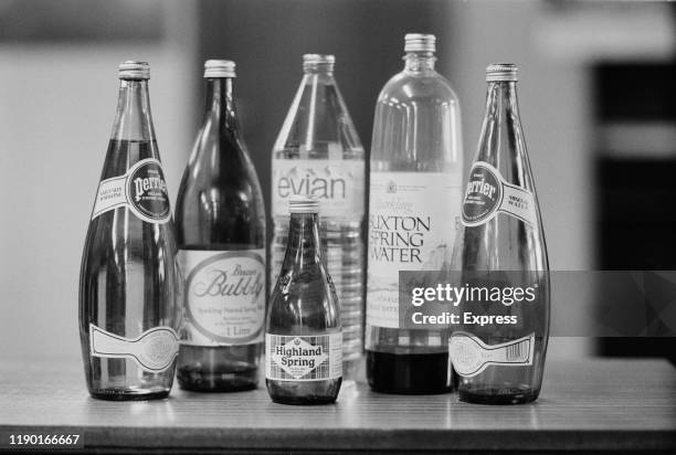 Selection of sparkling water bottles in glass, including Perrier, Evian, Highland Spring, Buxton, and Brecon Bubbly, UK, 10th September 1984.