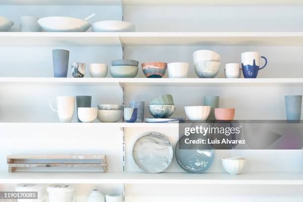 various earthenware on rack in pottery studio - plank meubels stockfoto's en -beelden