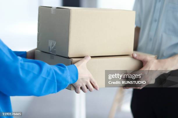 man receiving package from delivery man - 宅配便サービス ストックフォトと画像