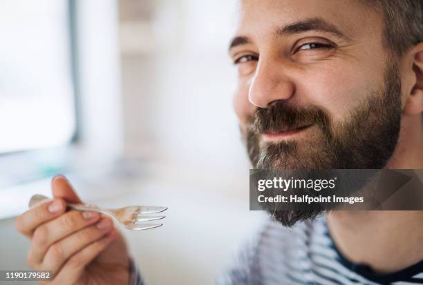 close-up of mature man indoors at home, eating cake. - enjoyment photos et images de collection