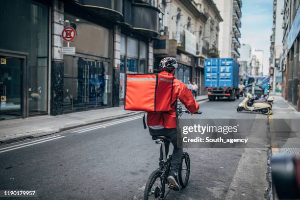 delivery boy on bicycle in city - delivery person stock pictures, royalty-free photos & images