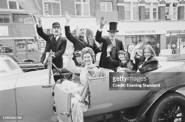 Stars of the British drama film 'The Railway Children' wave to spectators from a vintage car in London on the day of the film's premiere, 21st...