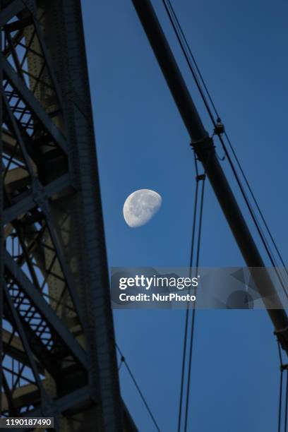 The moon through Williamsburg Bridge, a suspension bridge in New York City across the East River, connecting the Lower East Manhattan with...