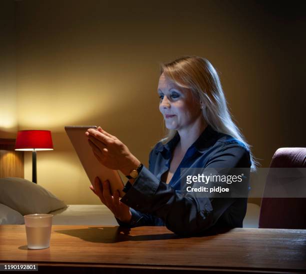タブレットpcを使用してホテルの部屋で働く女性 - jet lag ストックフォトと画像