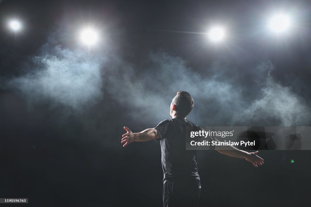 Soccer player shouting at stadium at night