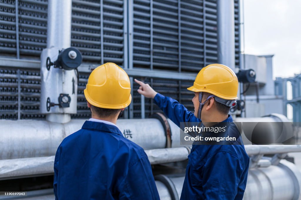 Two Engineer Colleagues Examining Cooling Tower Equipment