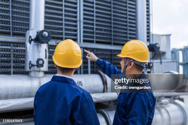 two engineer colleagues examining cooling tower equipment - water treatment stock pictures, royalty-free photos & images