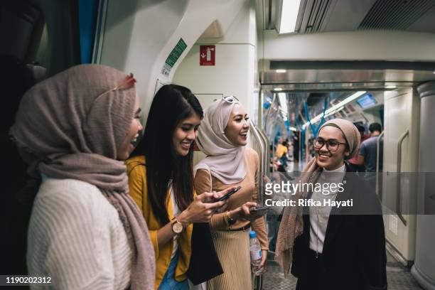 gruppe von geschäftsfrauen pendelzug zusammen - malaiischer herkunft stock-fotos und bilder