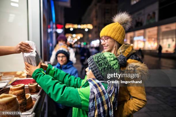 family buying traditional czech trdelnik cakes - trdelník stock pictures, royalty-free photos & images