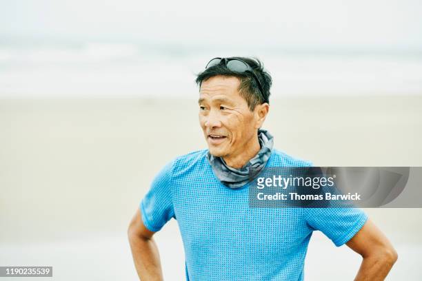 Senior man breathing hard after early morning run on beach