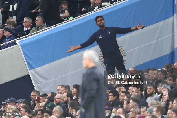 Flag for former Tottenham Hotspur manager Mauricio Pochettino is displayed in the crowd as Jose Mourinho, Manager of Tottenham Hotspur looks on...