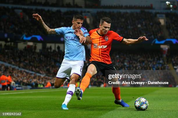 Joao Cancelo of Manchester City is held off by Yevhen Konoplyanka of Shakhtar Donetsk during the UEFA Champions League group C match between...