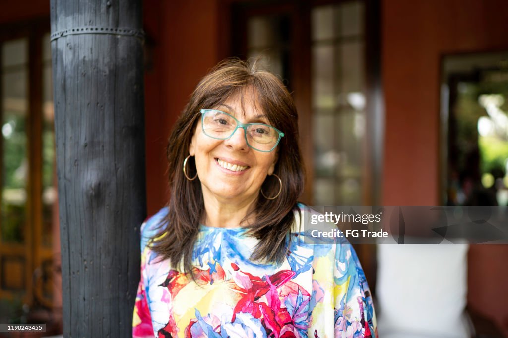 Portret van lachende rijpe vrouw thuis