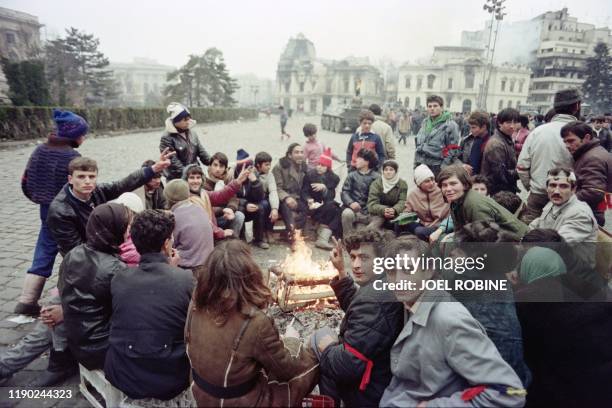Romanian civilians gather around a fire in the streets of Bucharest, on December 24 during fights to overthrow the Socialist Republic of Romania, as...