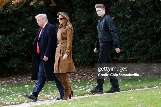 President Donald Trump, first lady Melania Trump and their son Barron Trump walk across the South Lawn before leaving the White House on board Marine...