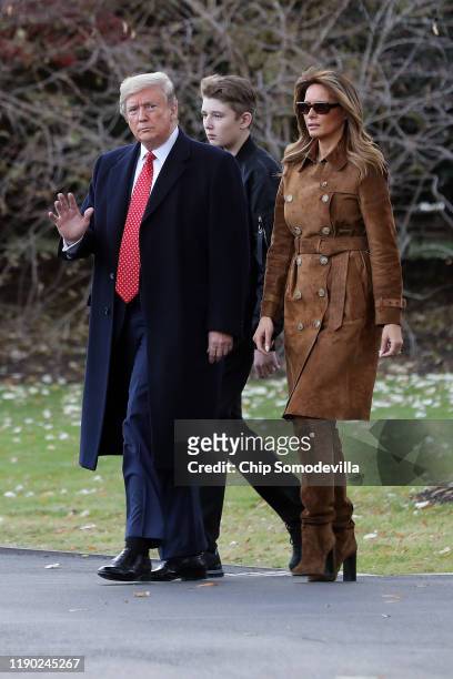 President Donald Trump, first lady Melania Trump and their son Barron Trump walk across the South Lawn before leaving the White House on board Marine...
