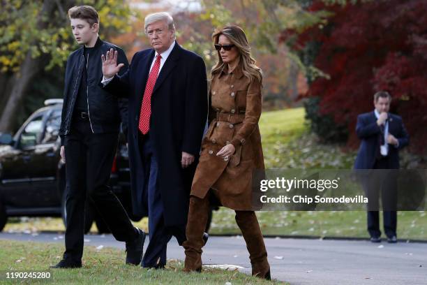 President Donald Trump, first lady Melania Trump and their son Barron Trump walk across the South Lawn before leaving the White House on board Marine...