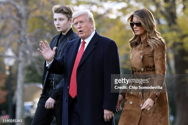 President Donald Trump, first lady Melania Trump and their son Barron Trump walk across the South Lawn before leaving the White House on board Marine...