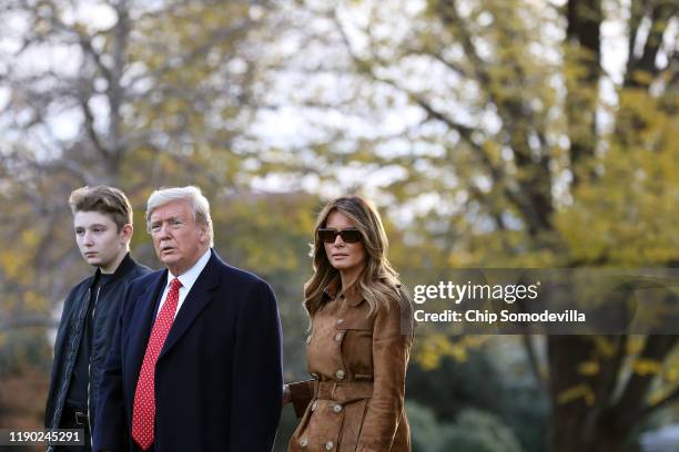 President Donald Trump, first lady Melania Trump and their son Barron Trump walk across the South Lawn before leaving the White House on board Marine...