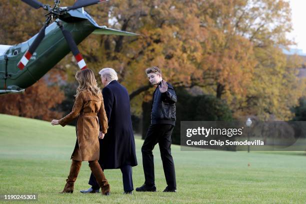 President Donald Trump, first lady Melania Trump and their son Barron Trump walk across the South Lawn before leaving the White House on board Marine...