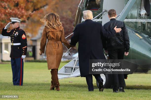 President Donald Trump, first lady Melania Trump and their son Barron Trump walk across the South Lawn before leaving the White House on board Marine...