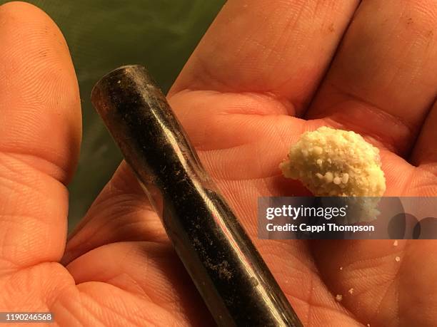 crack cocaine in man’s hand with crack pipe stem - crack epidemic stock pictures, royalty-free photos & images