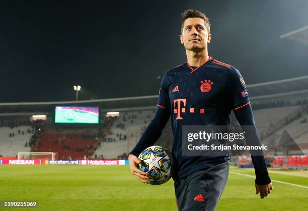 Robert Lewandowski of FC Bayern Munich celebrates with the match ball following his four goals during the UEFA Champions League group B match between...