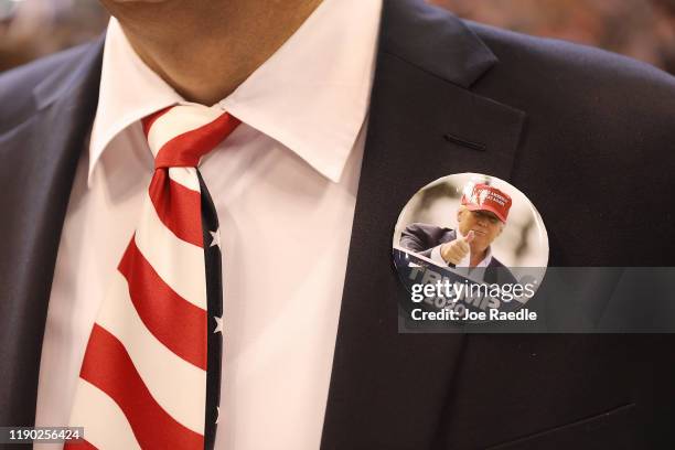Person wears a campaign button as he waits for the arrival of President Donald Trump at his homecoming campaign rally at the BB&T Center on November...