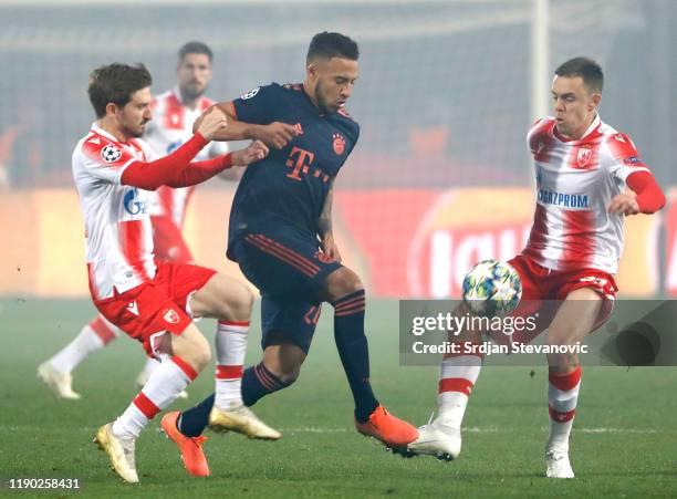 Corentin Tolisso of FC Bayern Munich battles for possession with Marko Marin and Milan Rodic of Crvena Zvezda during the UEFA Champions League group...