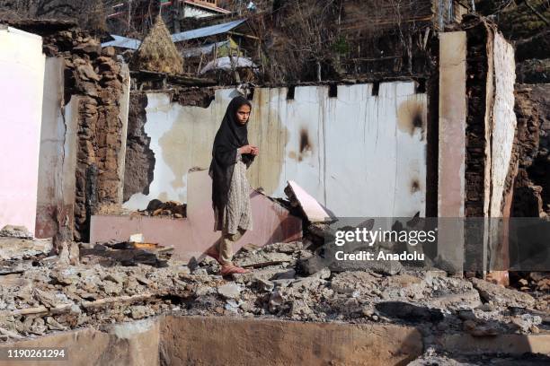 Pakistani Kashmiri girl villager stands on the debris of his house targeted by cross border Indian troops in a village in Neelum Valley on the Line...