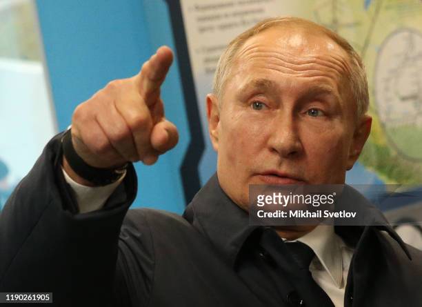 Russian President Vladimir Putin points while visiting the exhibition after riding a train across the bridge linking Russia and Crimean Peninsula at...