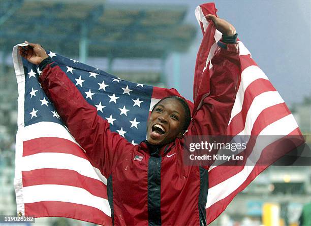 Tianna Madison of the United States celebrates with an American flag after winning the women's long jump at 22-7 1/4 in the IAAF World Championships...