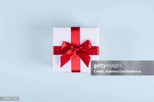 present or gift box, paper heart and confetti on blue background top view. valentines day greeting card. flat lay style. - heart box ribbon stockfoto's en -beelden