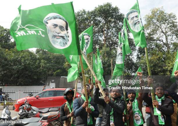 Jharkhand Mukti Morcha party workers celebrate after the Jharkhand assembly election results at state party headquarters on December 23, 2019 in...