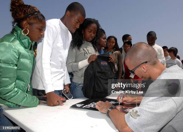 Jeremy Wariner, the 2004 Olympic gold medallist in the 400 meters, signs an autograph for Long Beach Poly High junior Joey Hughes in Long Beach,...