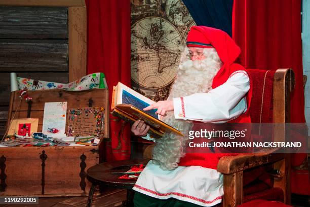 Santa Claus poses at his office near Rovaniemi, Finnish Lapland, on December 2, 2019. - Rovaniemi's Santa Claus Village amusement park is a...