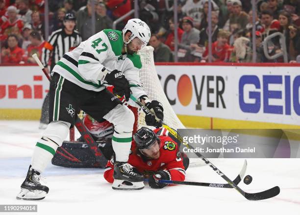 Duncan Keith of the Chicago Blackhawks tries to poke the puck away from Alexander Radulov of the Dallas Stars at the United Center on November 26,...