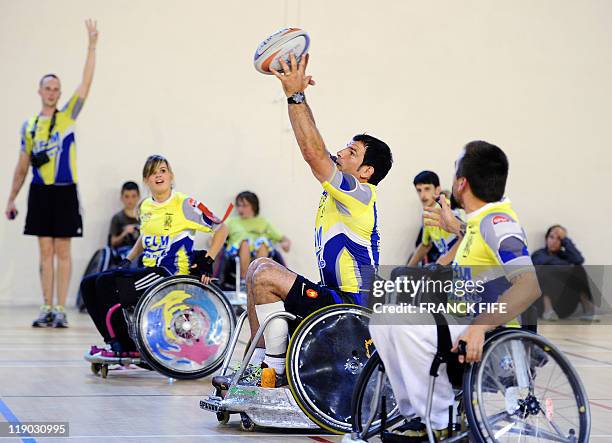 France's rugby union national team head coach Marc Lievremont , in a wheelchair, grabs the ball during a handi rugby match on July 14, 2011 in...