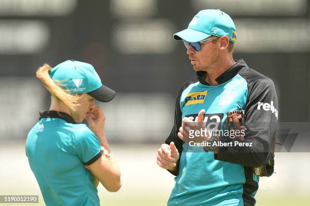 Brisbane Heat coach Ashley Noffke speaks to Kirby Short during Women's Big Bash League match between the Brisbane Heat and the Melbourne Renegades at...