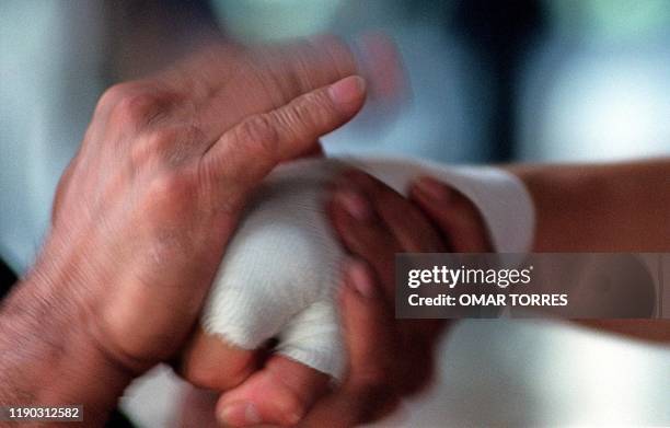 Graciela Ledezma's hand wrapped by her coach Javier Espinosa as she trains for a fight in Mexico City 30 August 2001. ILUSTRA NOTA: "MEXICANAS ENTRE...