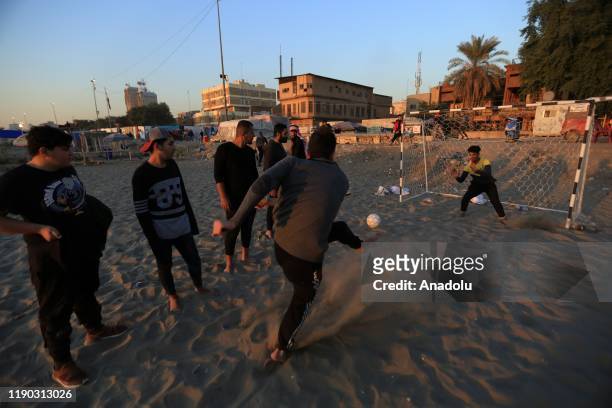 Iraqi youth play football at Tahrir beach in Baghdad, Iraq on December 23, 2109. Young protesters in Baghdad, continue to protest the government and...