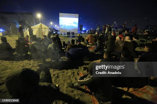 Iraqi youth attend an outdoor film screening at Tahrir beach in Baghdad, Iraq on December 23, 2109. Young protesters in Baghdad, continue to protest...