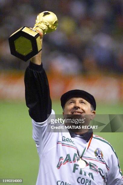 Mexican head coach Manuel Lapuente raises the trophy 04 August after his team defeated Brazil 5-4 in the final of the FIFA Confederations Cup...