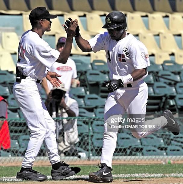 Miguel Tejada , stopper of the Aguillas de Cibao of the Dominican Republic, gives five to the coach Alex Tavera during a Caribbean Series game...